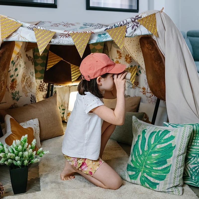 Little girl playing pretend camping