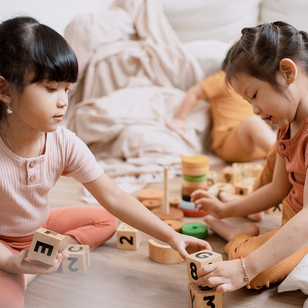 girls playing with natural wood blocks