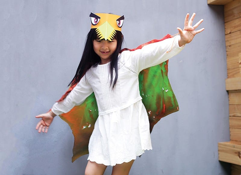 Girl playing pretend in a dinosaur costume