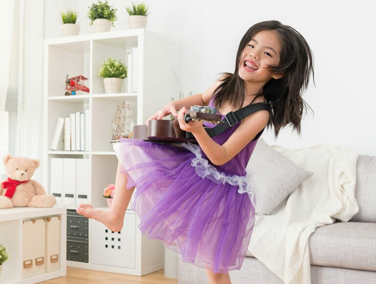 Asian girl playing guitar in joy